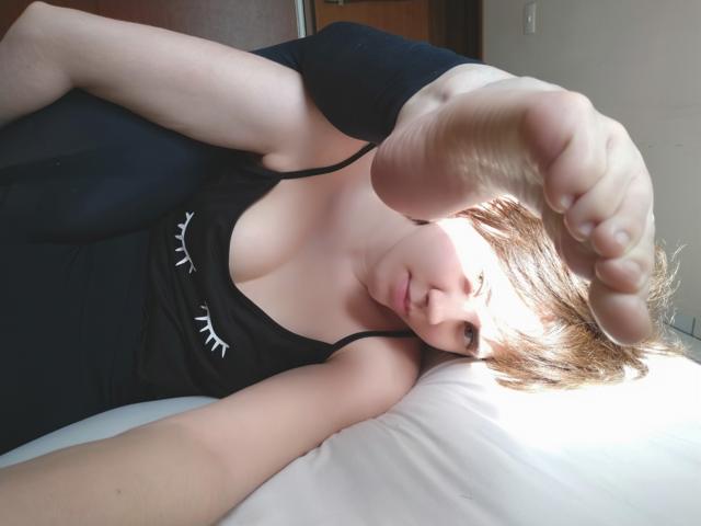 Sinara Desidério deitada com o pé ao lado do rosto