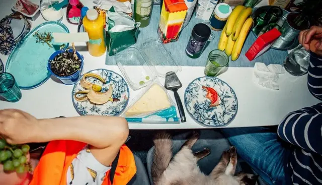 Deux hommes assis devant une table pleine de nourriture.