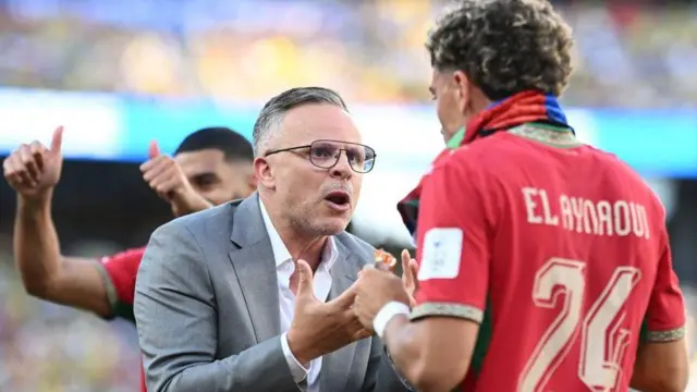 El seleccionador marroquí, Mohamed Ouahbi, le habla a Neil el Aynaoui durante una pausa de hidratación en su partido contra Brasil. 