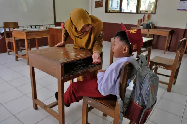 Seorang guru berinteraksi dengan murid baru saat Masa Pengenalan Lingkungan Sekolah (MPLS) di SD Negeri Butuh, Temanggung, Jawa Tengah, Senin (13/7/2026). SD Negeri Butuh hanya menerima dua murid baru selama dua tahun berturut-turut, dan pada hari pertama masuk sekolah tahun pelajaran 2026/2027 hanya seorang murid yang hadir karena satu murid lainnya sakit.