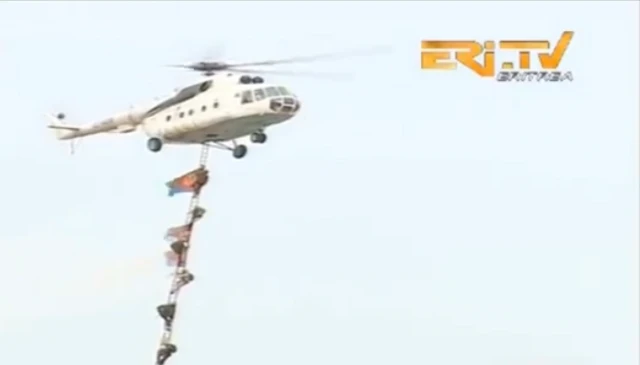 ኣብ 2019 ኣብ ዝተኻየደ ነፈርቲ ዝተሳተፍኦ ወተሃደራዊ ምርኢት ፍሉይ ሓይልታት ኤርትራ፡ ባንዴራ ዝሓዘ ዝርከቦም ሓያለ ወተሃደራት ካብ ሄሊኮፕተር እናወረዱ