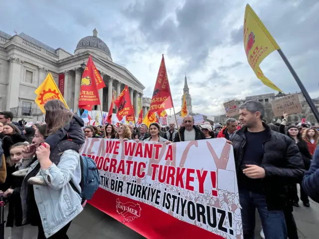Londra'da Trafalgar Meydanı'nda bir araya gelen topluluk "Demokratik bir Türkiye İstiyoruz" yazılı pankart taşıyor.