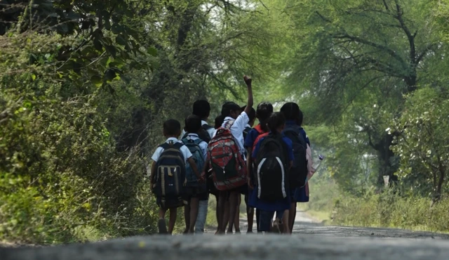 जंगलातल्या रस्त्यानं शाळेत जाणारी मुलं 