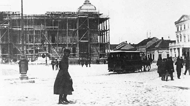 Први трамвај пролази тадашњим Позоришним тргом (данашњи Трг Републике), а у позадини се може видети споменик кнезу Михаилу Обреновићу