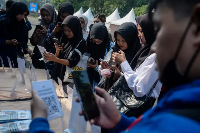 Pencari kerja memindai kode respons cepat perusahaan saat bursa kerja di Kota Tangerang, Banten, Kamis (26/6/2025).