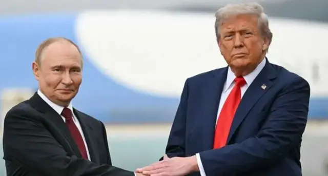 Путін у чорному діловому костюмі, Трамп у синьому, тиснуть руки