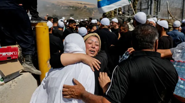 Una mujer drusa de Siria se reúne con su hermana al cruzar al lado israelí desde la frontera abierta