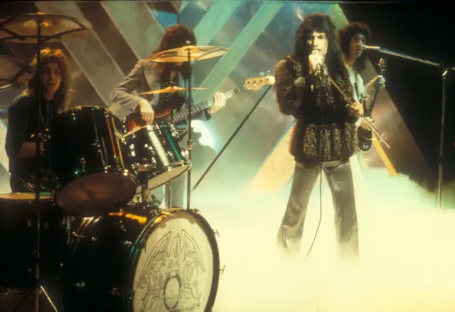 La imagen muestra a Queen en el programa Top of the Pops, con el vocalista Freddie Mercury.
