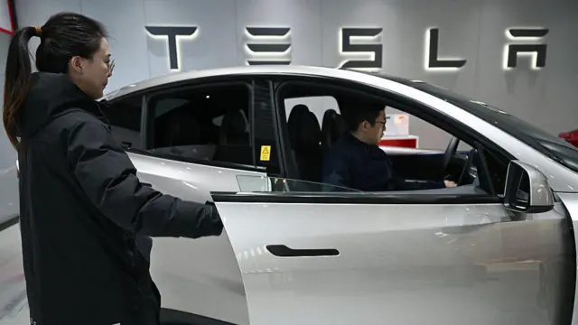 2026年2月3日，一名女子在北京一家特斯拉展廳為一輛特斯拉Model YL電動車打開車門。