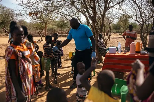 Andrew Ochieng examine des villageois près de sa clinique de fortune pour la leishmaniose viscérale, à l'ombre d'un arbre à Akorikeya.