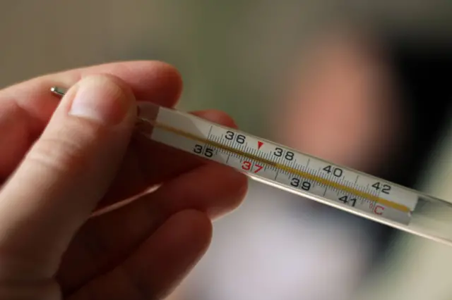 sur un arrière-plan flou d’une petite fille malade, couché sur un lit. Vérifier la température. Fièvre, maladie, frissons, soins.