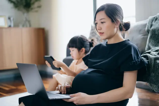 一名女性在家育兒兼工作。