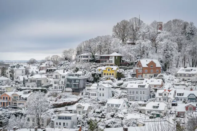 Una fotografía panorámica de un pueblo nevado. 