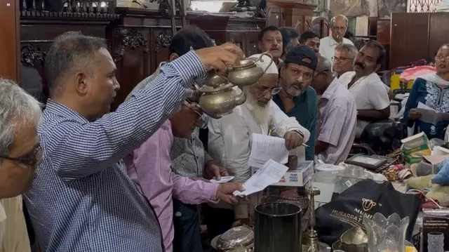 नीलामी में हिस्सा लेते हुए लोग