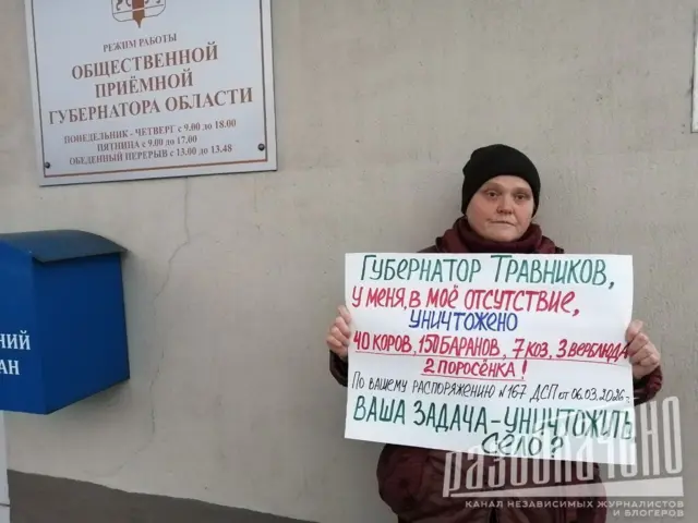 Женщина с плакатом, на котором говорится, что ее животных убили в ее отсутствие из-за подозрений на инфекционные заболевания