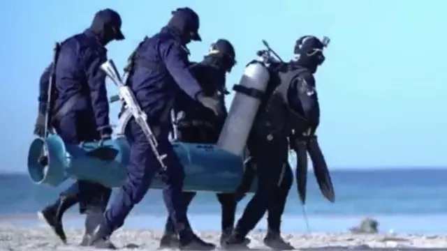 Quatro membros da Al-Qassam carregam o torpedo 'Al Asef' para o marseleção finlandesa de futebolvídeo