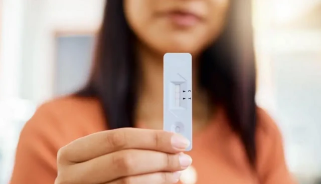 કોરોનાની ટેસ્ટિંગ માટેની કિટ સાથે મહિલાની તસવીર 