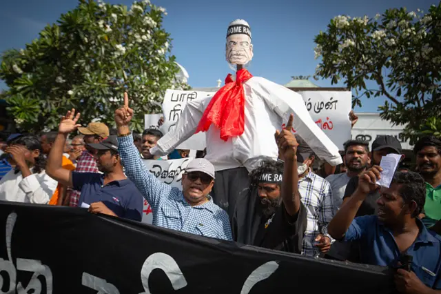 Demonstrators take part in a procession carrying an effigy of interim Sri Lanka's President Ranil Wickremesinghe during a protest in front of the Fort railway station in Colombo on July 19, 2022. 