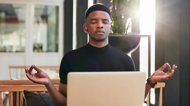 Homem meditandocupom esportes da sorteolhos fechadoscupom esportes da sortefrente a laptop