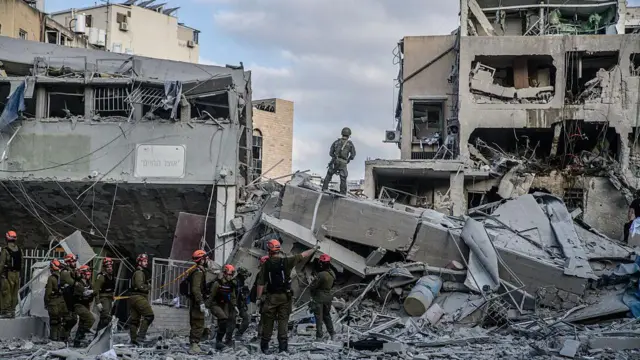 16 Haziran'da Tel Aviv'de Bnei Brak bölgesinde acil durum görevlileri, İran'ın füze saldırısında doğrudan isabet alan bir evdeki yaralıları arıyor