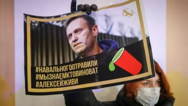 Taageere Navalny ah ayaa sita boor ay ku qoran tahay: "Navalny waa la sumeeyay, waan ognahay cidda eedda leh, Alexei, noolow."