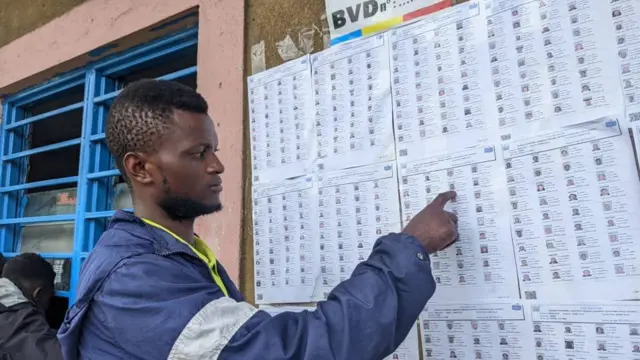 Un jeune pointe du doigt son nom sur la liste