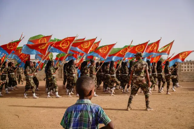 Ilmo ayaa daawanaya socdaalka calan-sidayaasha milatariga xilli lagu guda jiray dabaaldega Maalinta Xorriyadda ee Eritrea oo ka dhacaysay Barentu, Eritrea, 21-kii May, 2023.
