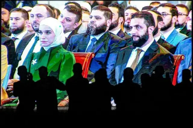 احمد شرع و همسرش در یک مراسم در کنار هم نشسته‌اند