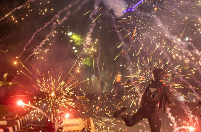 Personel kepolisian menghindari tembakan petasan dari pengunjuk rasa saat patroli pembubaran pengunjuk rasa di Jalan Pahlawan, Kota Semarang, Jawa Tengah, Jumat (29/8/2025).

