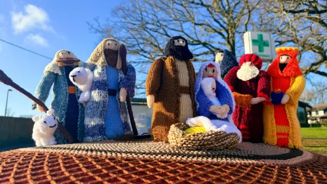 Un belén tejido encima de un buzón.