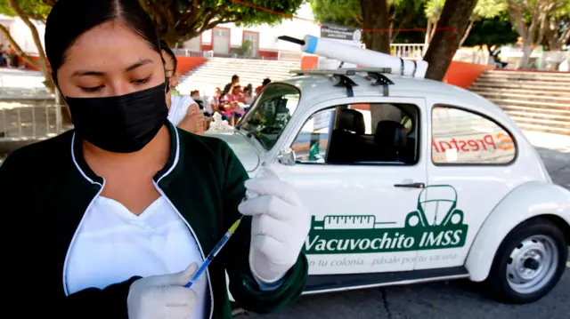 ভ্যাকসিনের শিশি হাতে একজন নারী