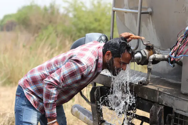 తీవ్రమైన ఎండలో తలను తడుపుకుంటున్న వ్యక్తి