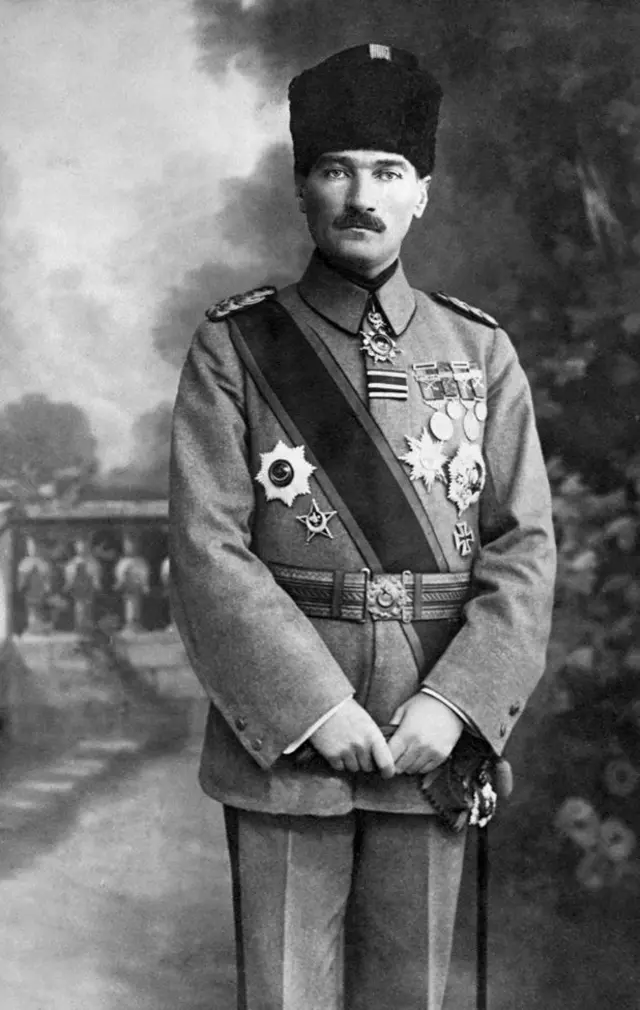 Kemel Ataturk con un uniforme militar y varias medallas colgadas. Lleva en su cabeza un tarboosh y tiene atravesada en el torso una banda
