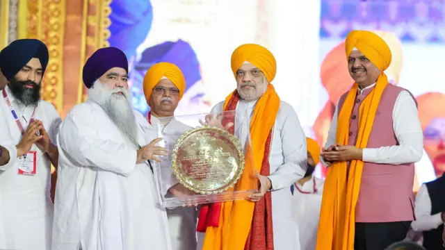 ਕੇਂਦਰੀ ਗ੍ਰਹਿ ਮੰਤਰੀ ਅਮਿਤ ਸ਼ਾਹ ਅਤੇ ਮਹਾਰਾਸ਼ਟਰ ਦੇ ਮੁੱਖ ਮੰਤਰੀ ਦੇਵੇਂਦਰ ਫੜਨਵੀਸ ਨਾਲ ਦਮਦਮੀ ਟਕਸਾਲ ਦੇ ਮੁਖੀ ਹਰਨਾਮ ਸਿੰਘ ਧੂੰਮਾ