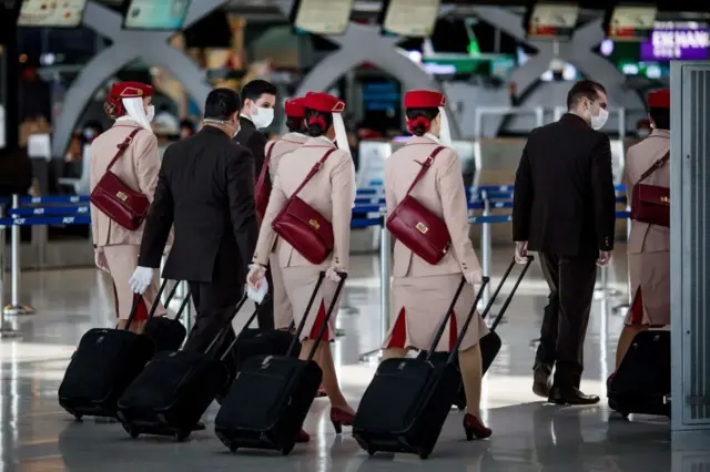 Airline flight crew wearing face masks as a preventative measure against Covid-19 coronavirus walks through the departure terminal of Suvarnabhumi International Airport in Bangkok on December 18, 2020. 