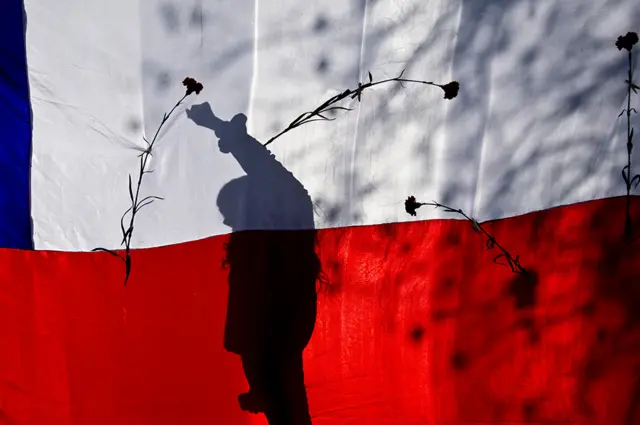 Uma bandeira chilena e rosas durante uma marchabet pixioSantiagobet pixiomemória do presidente deposto Salvador Allende