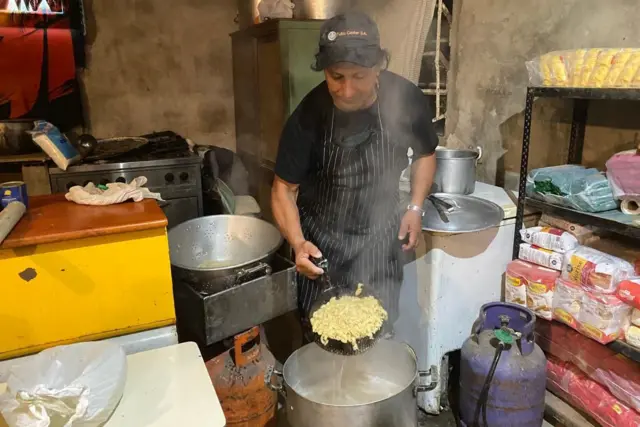 José Cuello preparando macarrão no refeitório Un Lugarcito.