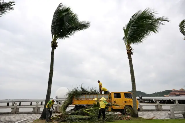 Radnici uklanjaju grane sa obale dok se tajfun približava Kini