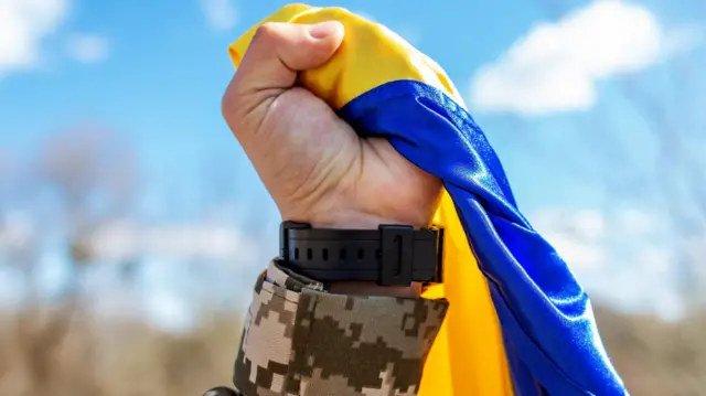 यूक्रेन का एक झंडा लिए हुए यूक्रेनी सैनिक.