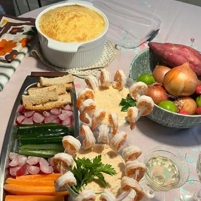 Mesa com suflê, frios, cenoura e camarão