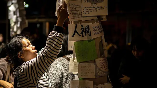 2025年11月30日，一名女子在香港大埔区宏福苑外贴上一张纸条，悼念11月26日造成人员伤亡的火灾。