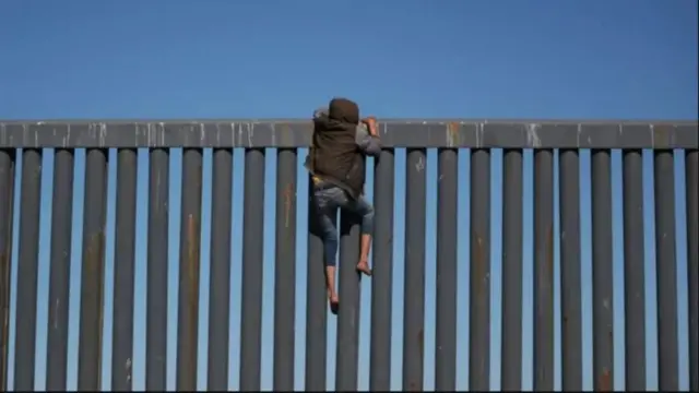 Muhojir chegara devoridan oshib o‘tishga urinayotgan lahza.