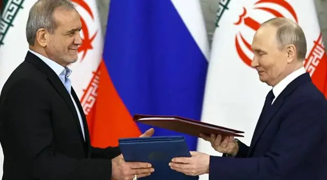 مسعود پزشکیان و ولادیمیر پوتین در حال رد و بدل کردن توافقنامه‌ها