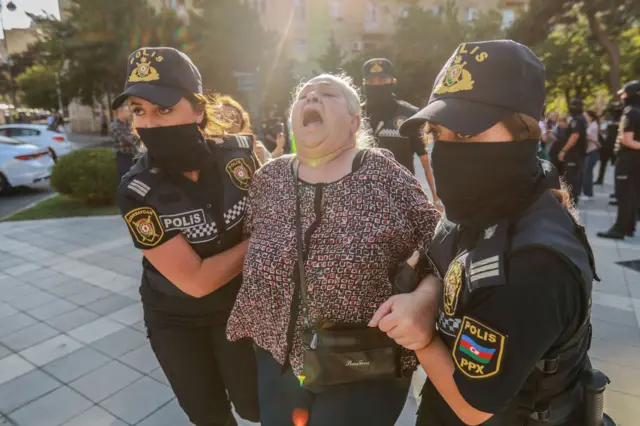 Пожилую женщину задерживают на митинге полицейские