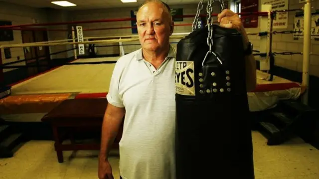 Chuck Wepner devant un ring de boxe.