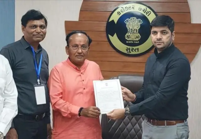 ભાજપના ઉમેદવાર મુકેશ દલાલને (ડાબે) વિજયનું સર્ટિફિકેટ આપી રહેલા કલેક્ટર ડૉ. સૌરભ પારઘી