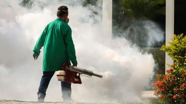 Homem aplicando fumacê