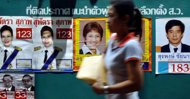 Bangkok, THAILAND: A woman walks past a billboard with pictures of candidates for the general election in central Bangkok, 31 March 2006. Prime Minister Thaksin Shinawatra vowed to ride out the political turmoil engulfing Thailand, two days before elections called as a referendum on his leadership. AFP PHOTO/ BAY ISMOYO (Photo credit should read BAY ISMOYO/AFP via Getty Images)