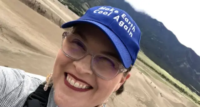 Sarah Ott ve şapkasında 'dünyayı yeniden soğut' yazıyor.