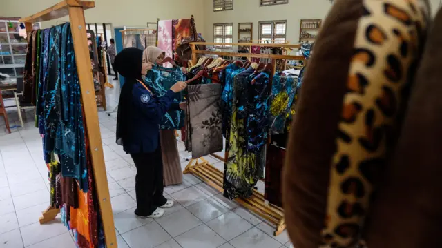 Penerima manfaat didampingi pelatih menata produk kerajinan yang dibuatnya di sentra terpadu Balai Besar Rehabilitasi Sosial Penyandang Disabilitas Fisik (BBRSPDF) Prof. Dr. Soeharso Surakarta, Solo, Jawa Tengah, Kamis (15/1/2026). 